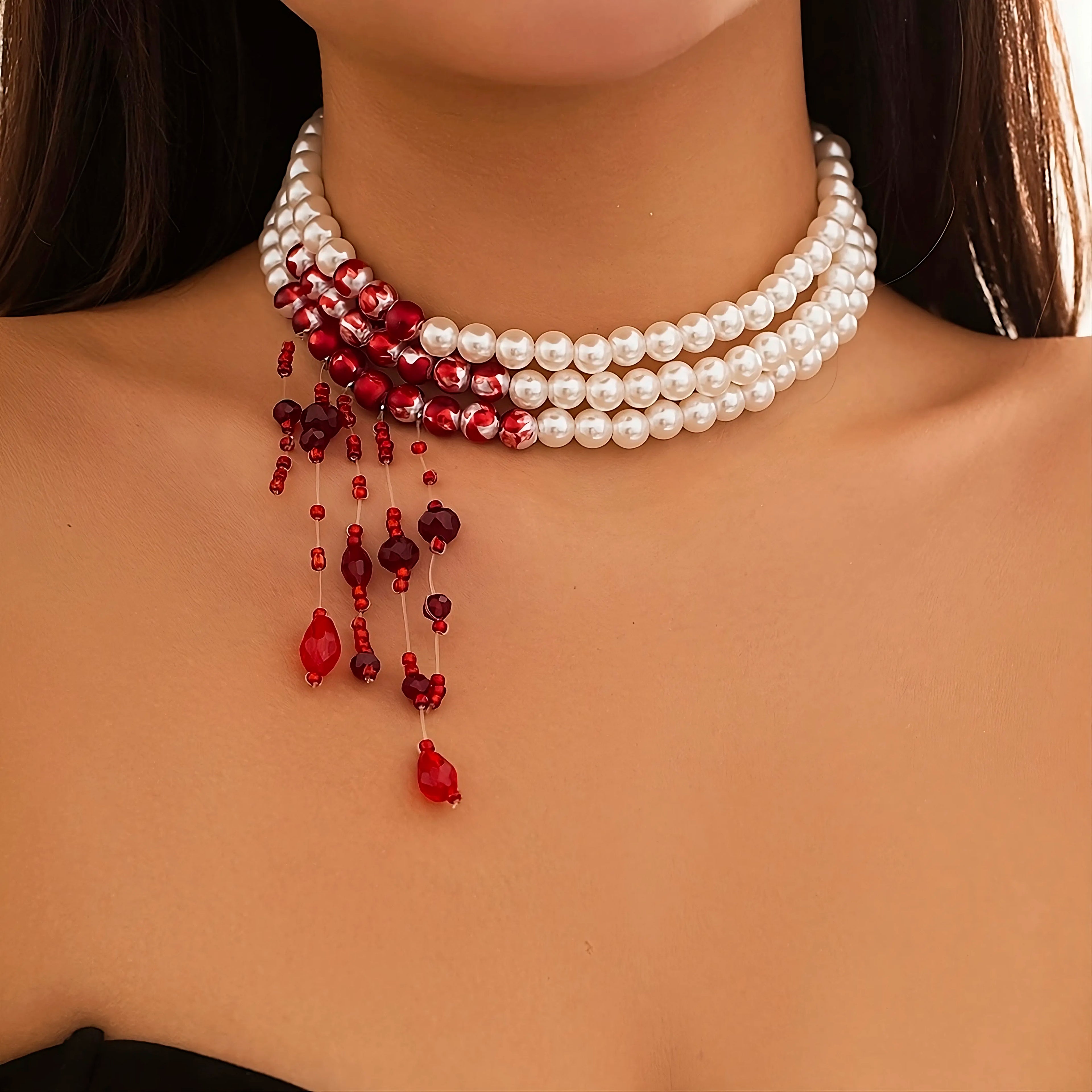 Woman wearing a necklace with imitation blood hanging from imitation pearls.